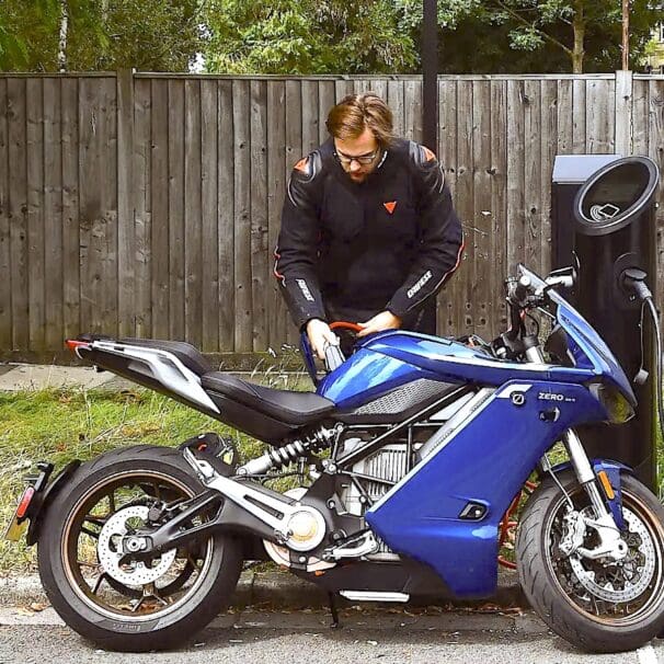 A view of an electric motorcycle plugged in for a charge. Media sourced from Autocar.