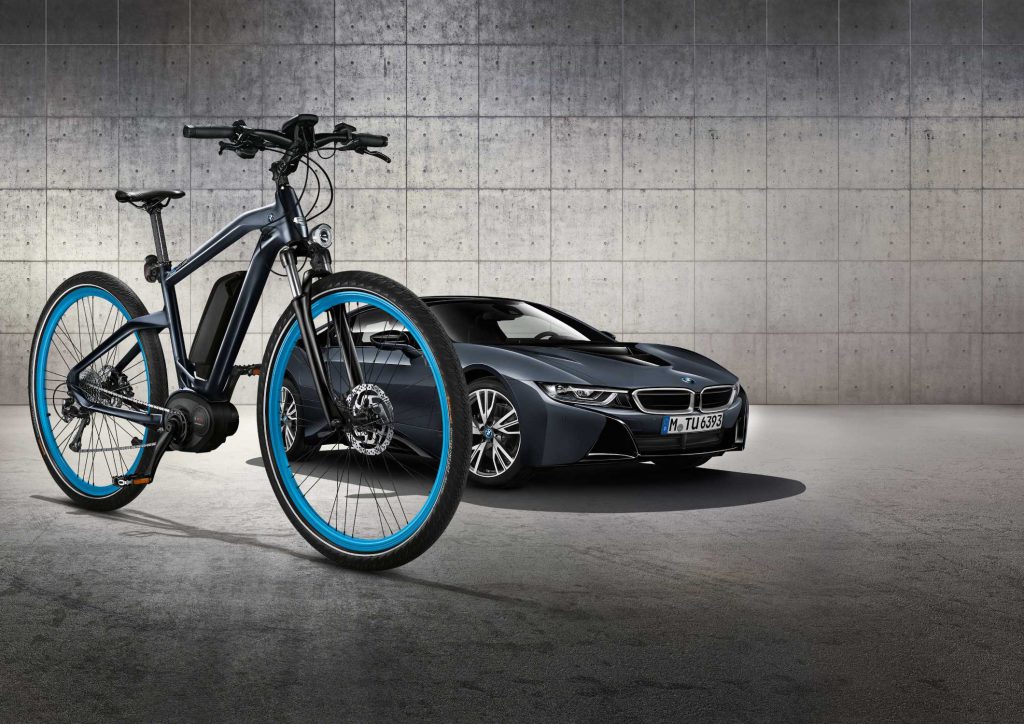BMW branded electric bike next to BMW i8 car