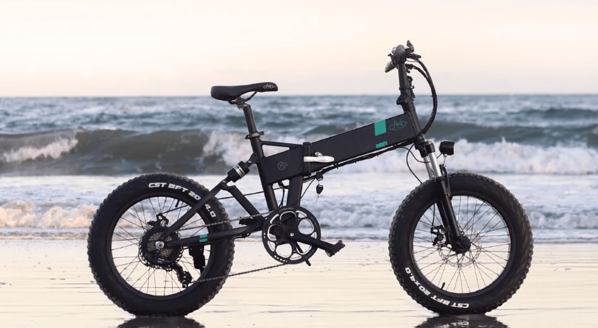 Fiido M21 folding fat tire eBike balanced on beach with waves in background