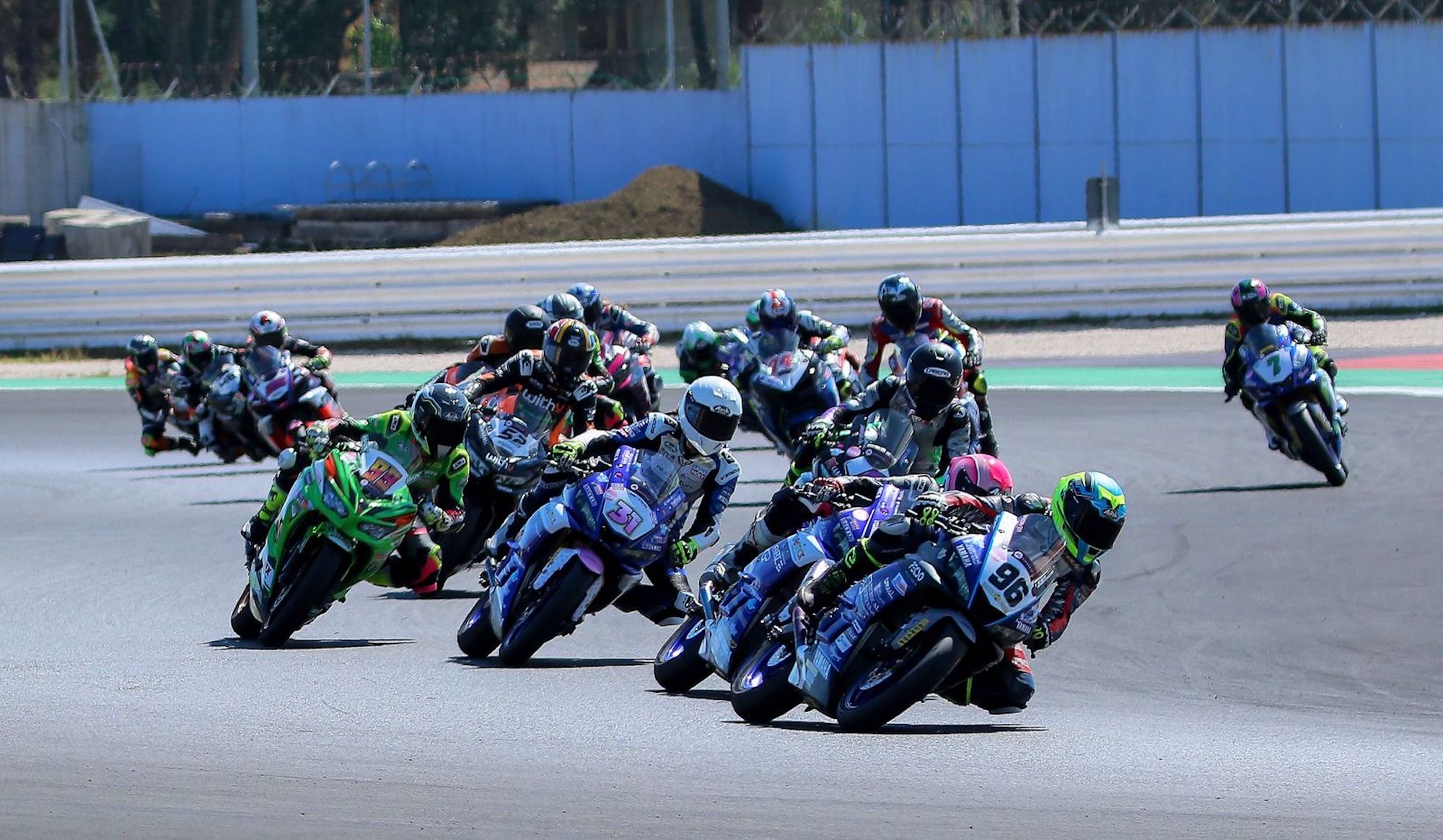 Motorcycle racers leaning into the twisties of. racing circuit. Media sourced from GPOne.