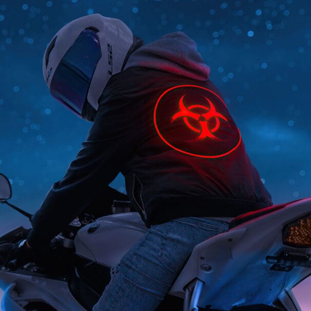 A biker with a biohazard sign on their hoodie. Media sourced from Rare Gallery.