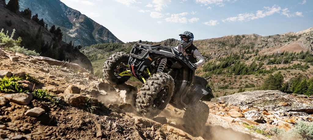 A rider on a Sportsman XP 1000 S traversing through some rugged terrain