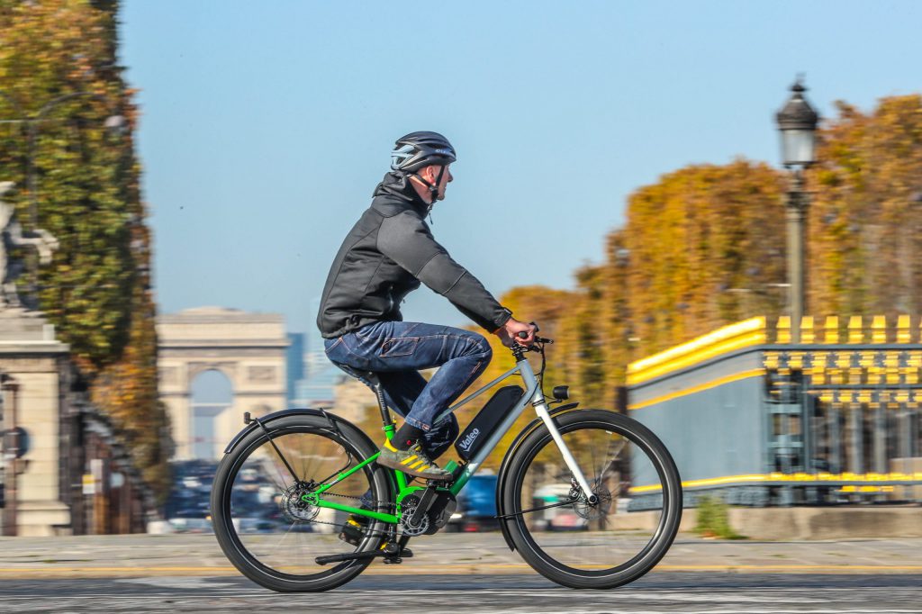 Commuting man riding electric bike through city