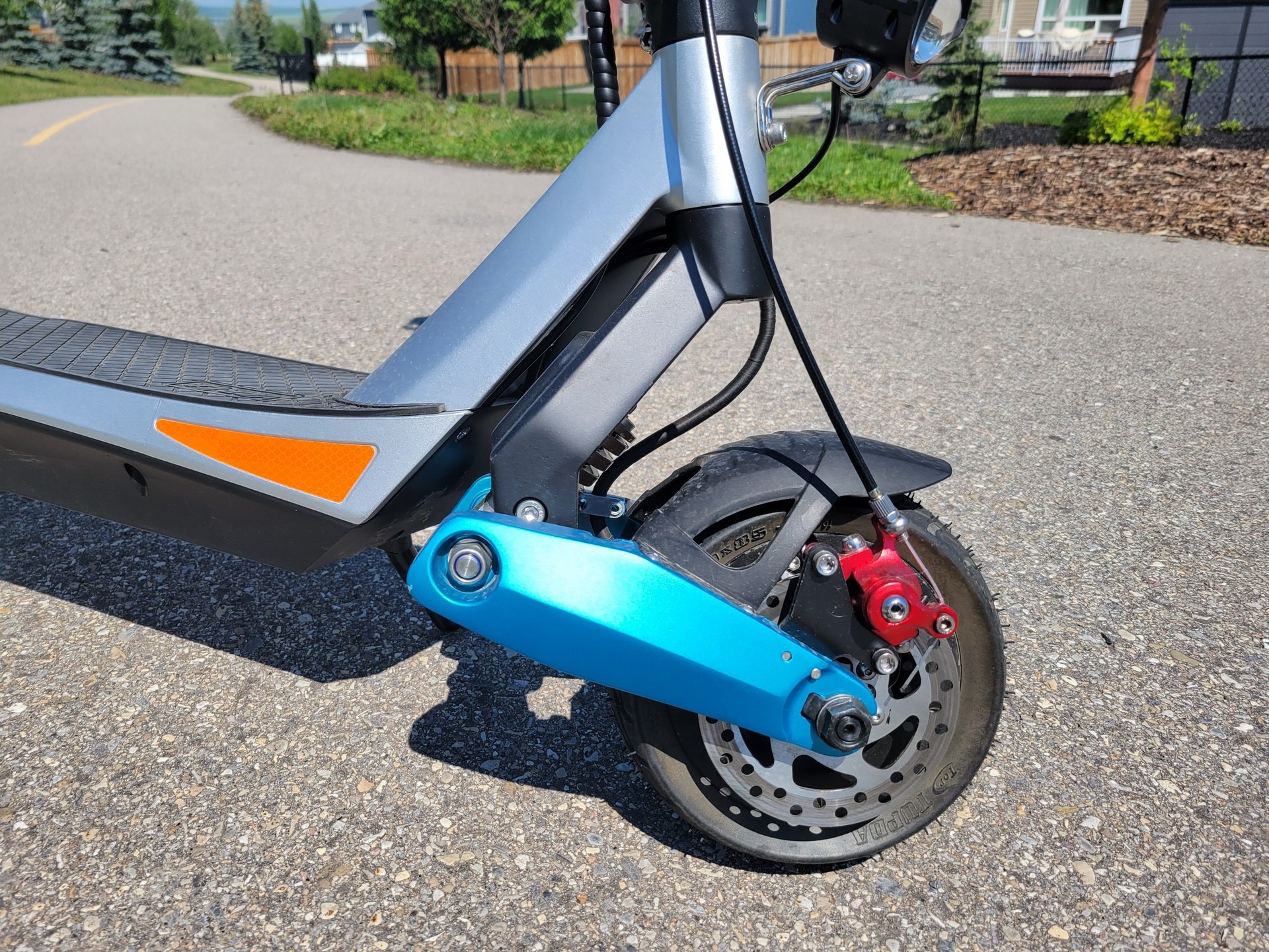 Front wheel and teal swing arm on Varla Pegasus Scooter