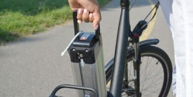 Rider removes battery pack from their electric bike on roadside