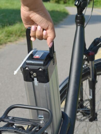 Rider removes battery pack from their electric bike on roadside