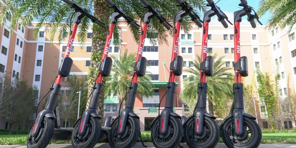 Row of rental electric scooters lined up in urban area