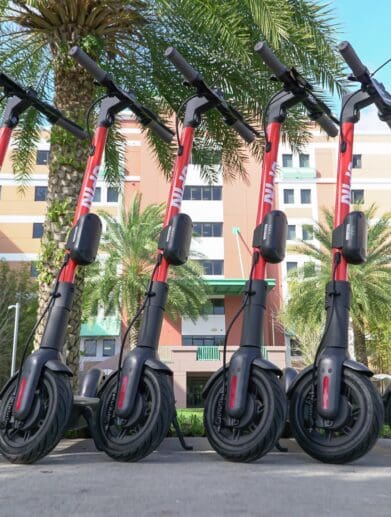 Row of rental electric scooters lined up in urban area