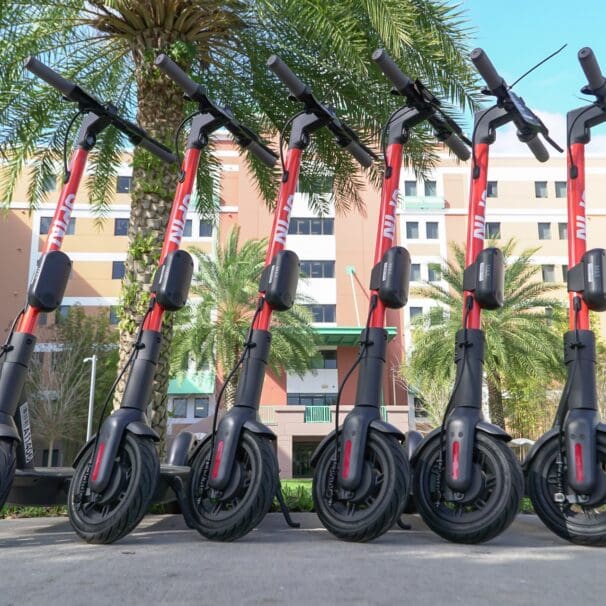 Row of rental electric scooters lined up in urban area