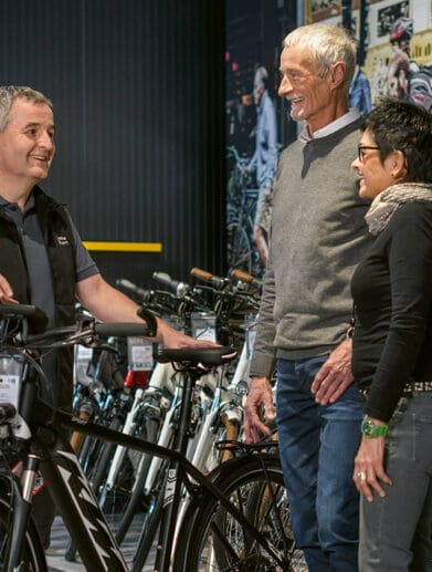 Bosch employee holding electric street bike talking to customers