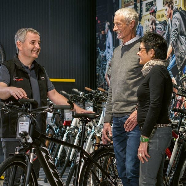 Bosch employee holding electric street bike talking to customers