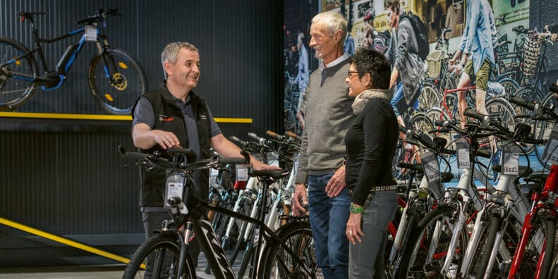 Bosch employee holding electric street bike talking to customers