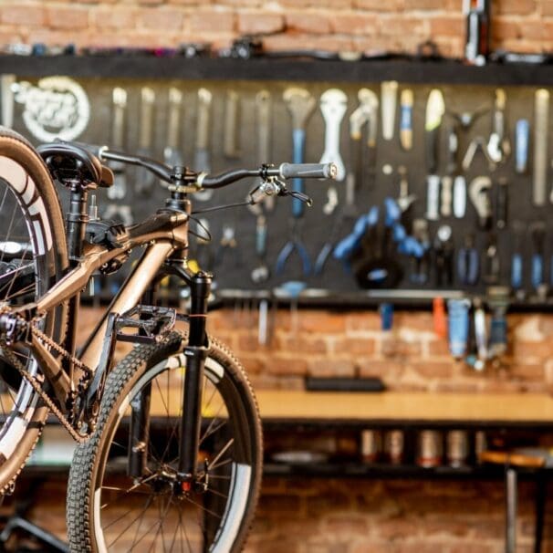 Mountain bike resting on bike stand in workshop with tools on wall