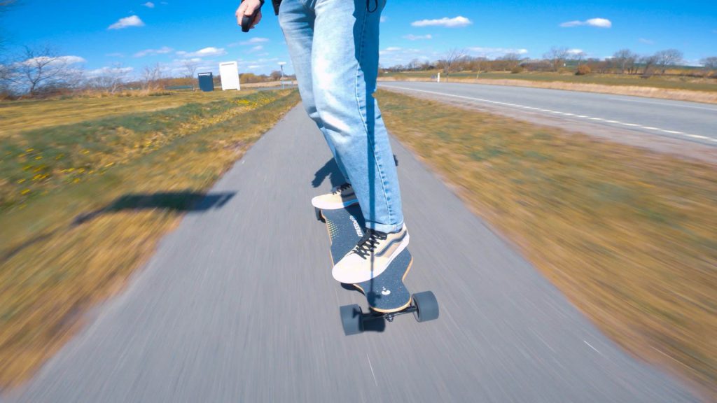 Man rides electric skateboard on pedestrian path