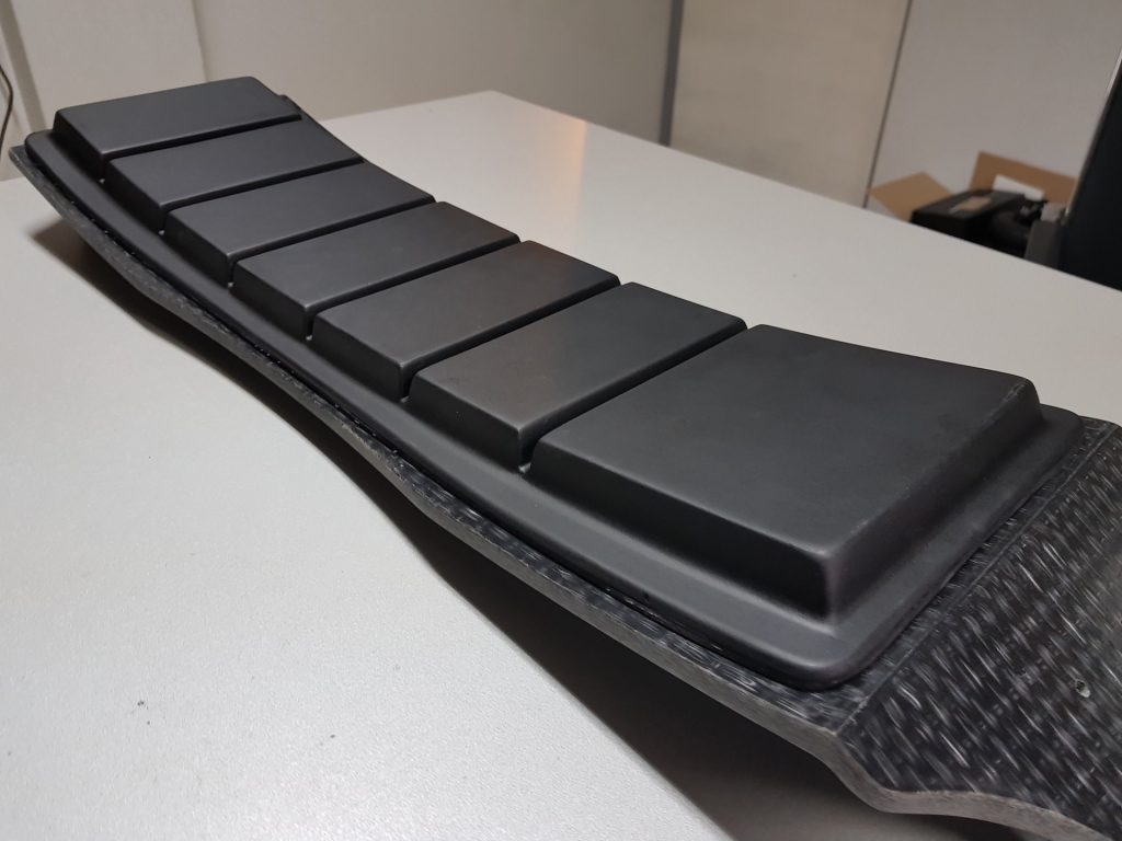 Arched DIY electric skateboard case unsealed and resting on table