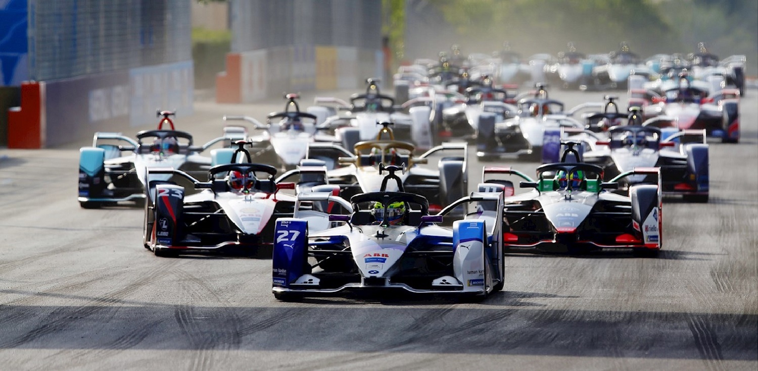 Competing Formula E electric F1 race cars driving on track during championship