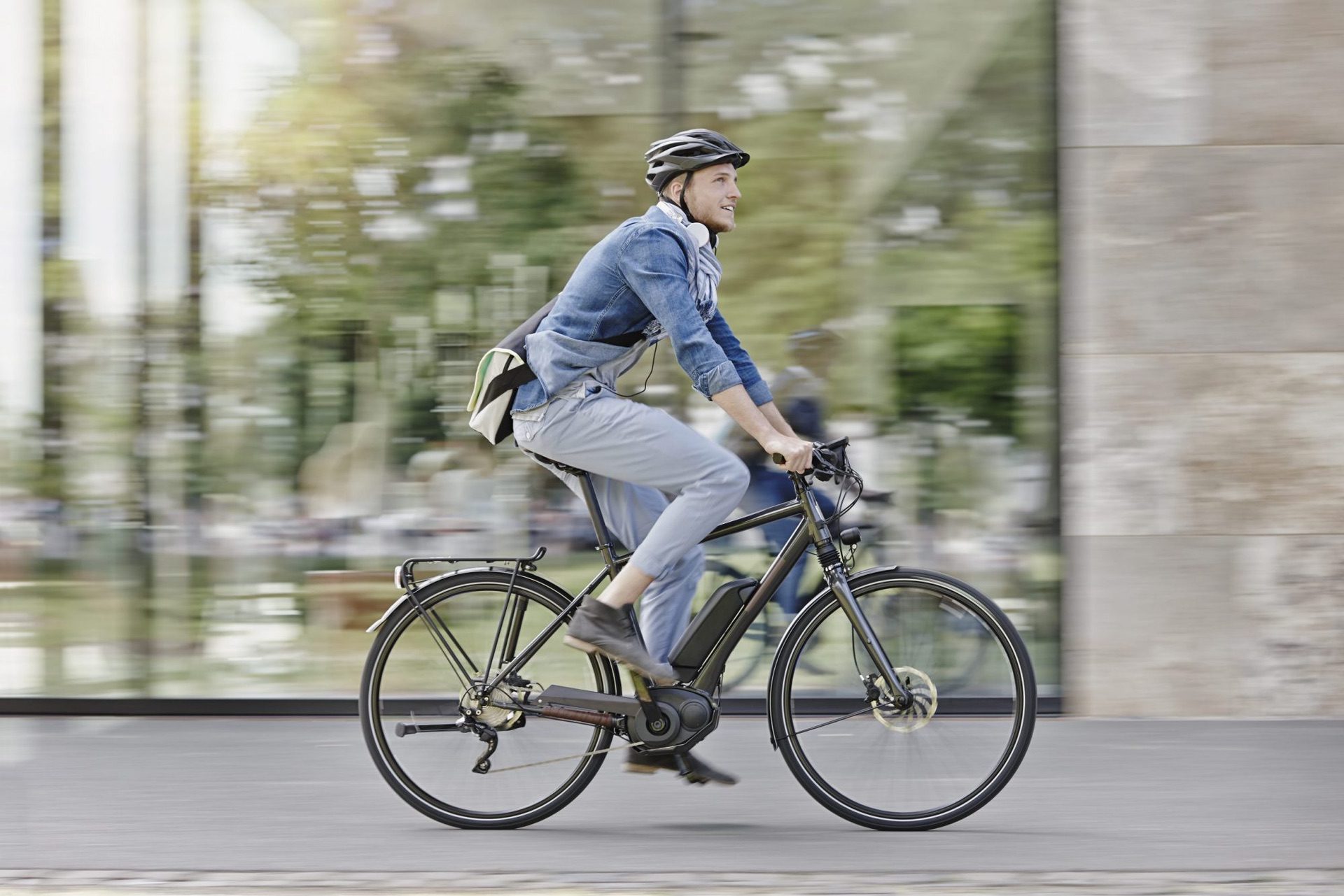 Commuter rides electric bike through inner city on bright day