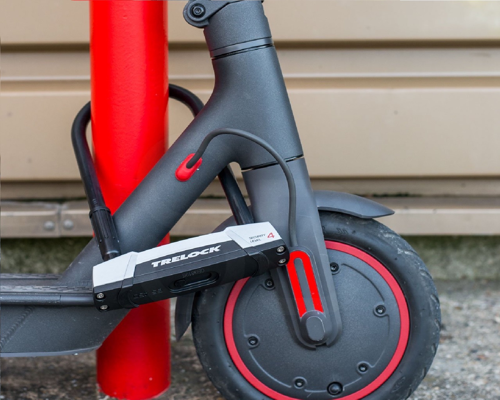 Electric scooter fixed to post with Trelock D-lock in urban environment