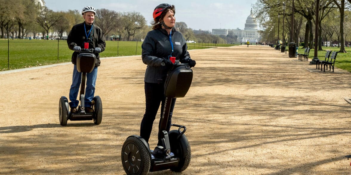 Couple riding Segway personal transporters through Washington State Park