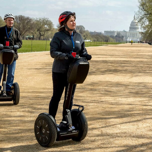 Couple riding Segway personal transporters through Washington State Park