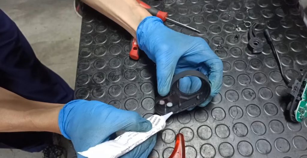 Man applying silicone gel to Zero X10 eScooter display for waterproofing