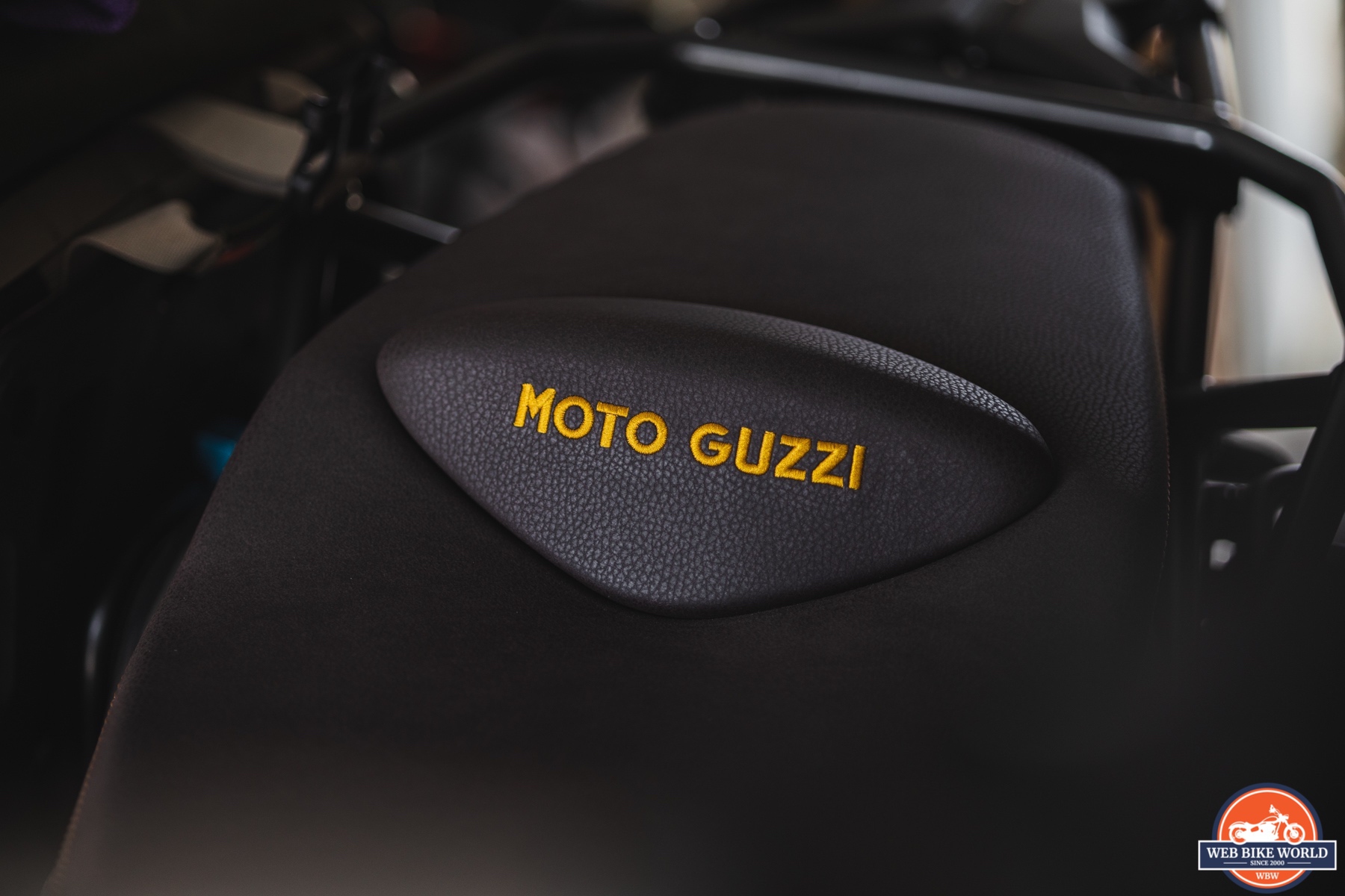  Close-up photo of a 2021 Moto Guzzi V85TT Centenario leather seat with gold stitching