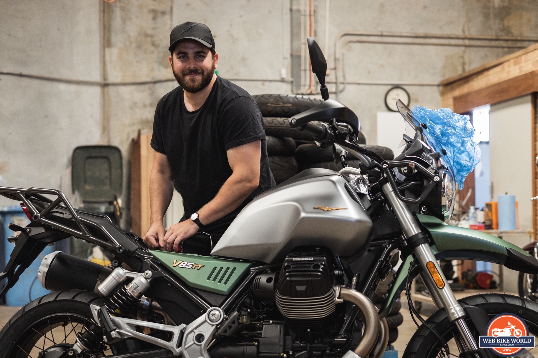 Side photo of a 2021 Moto Guzzi V85TT Centenario with happy man