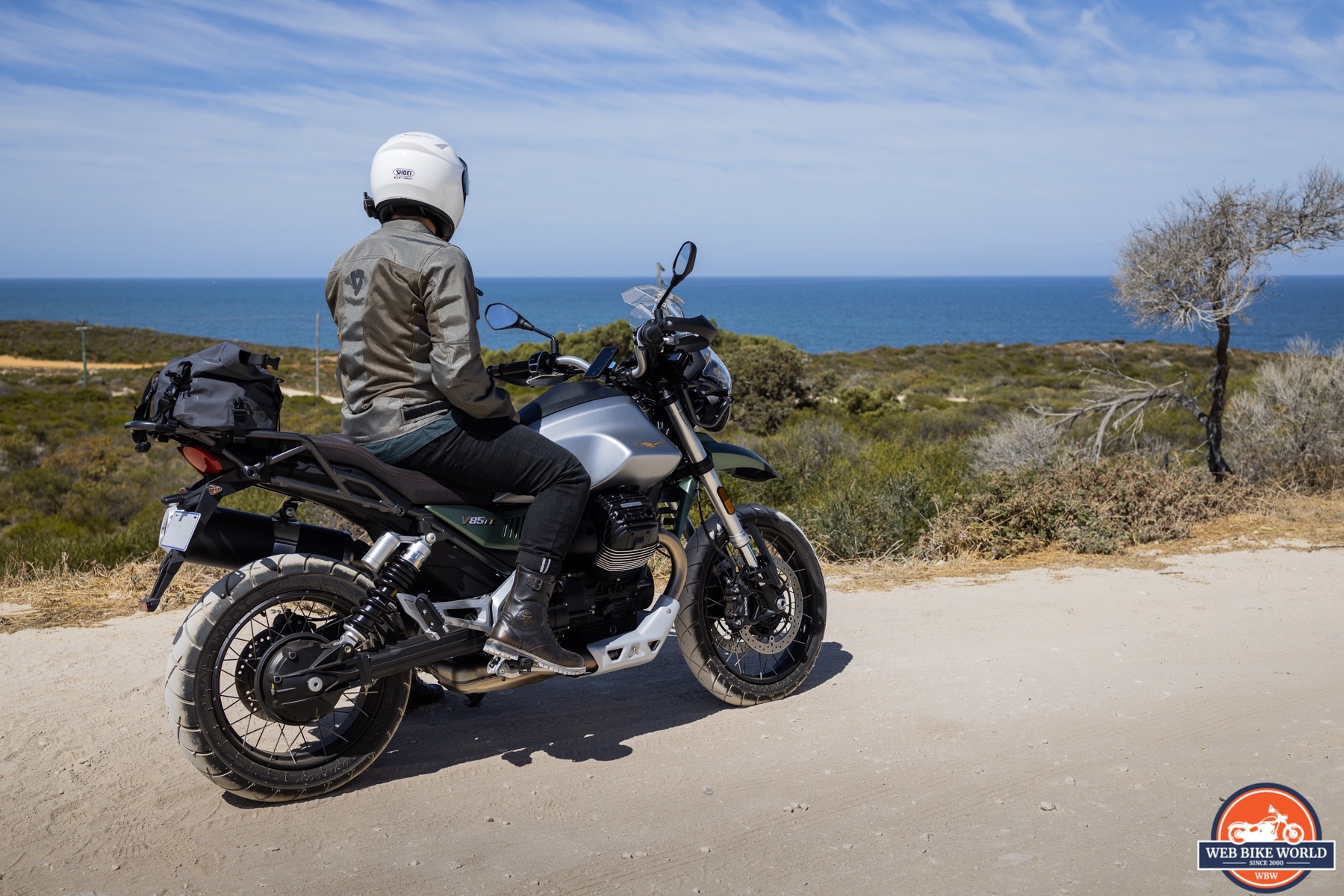 Right side photo of a 2021 Moto Guzzi V85TT Centenario and rider on a beach