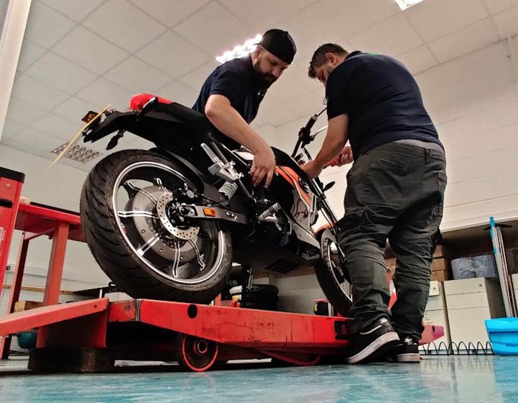 A pair of citizens working on the servicing of an electric motorcycle. Media sourced from Go Green Motorcycles.