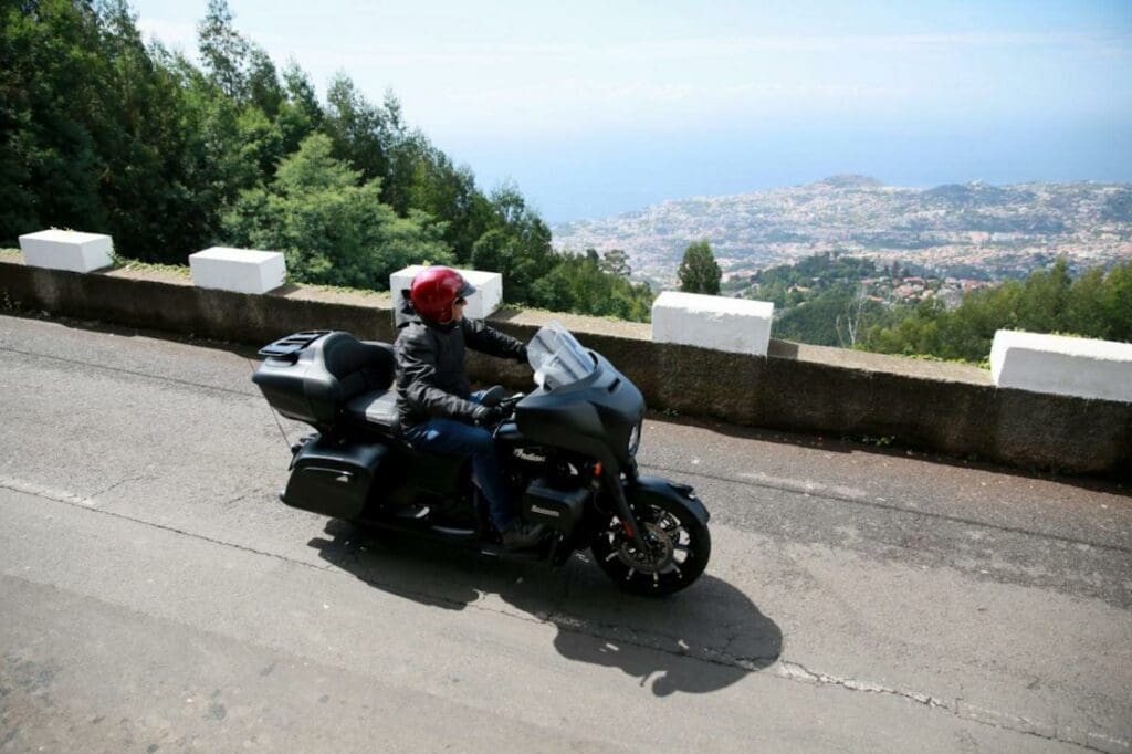 An Indian bike and rider gazing out over a hazy distance in Madeira. Media sourced from Visordown.