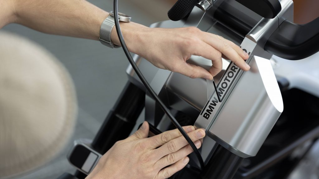 A view of someone peeling the stickers off of a new BMW CE scooter. Leave the darn thing on, dang it. 