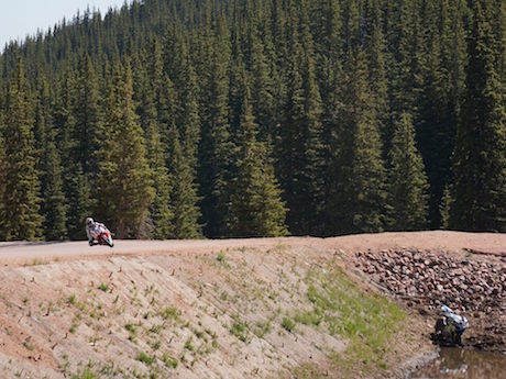 Motorcycle overall wnner Jeffrey Tigert on a Honda CBR1000RR asses the crashed Ducati at Pikes Peak