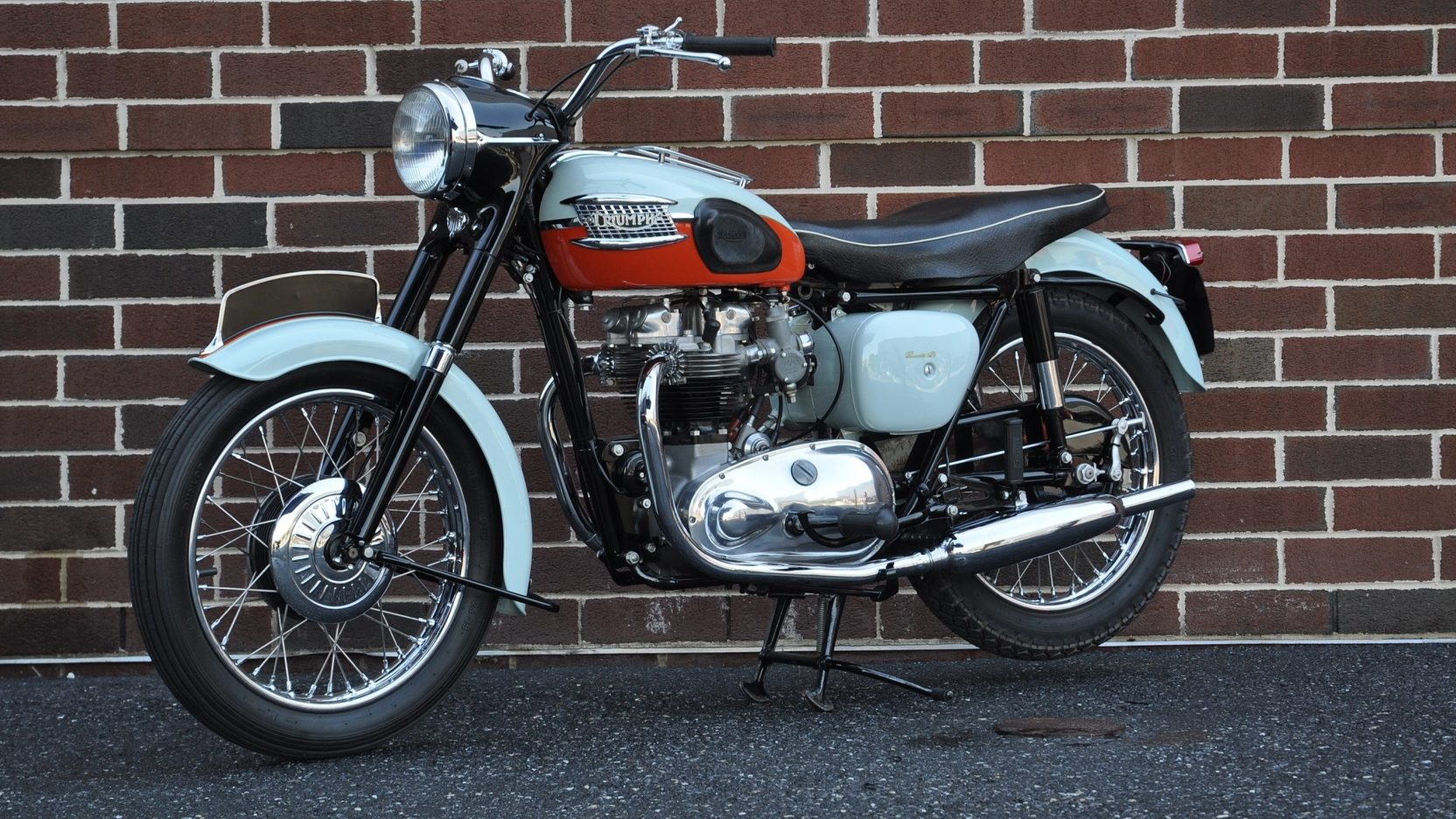 1959 Triumph Bonneville T120 Parked In Front Of A Brick Wall