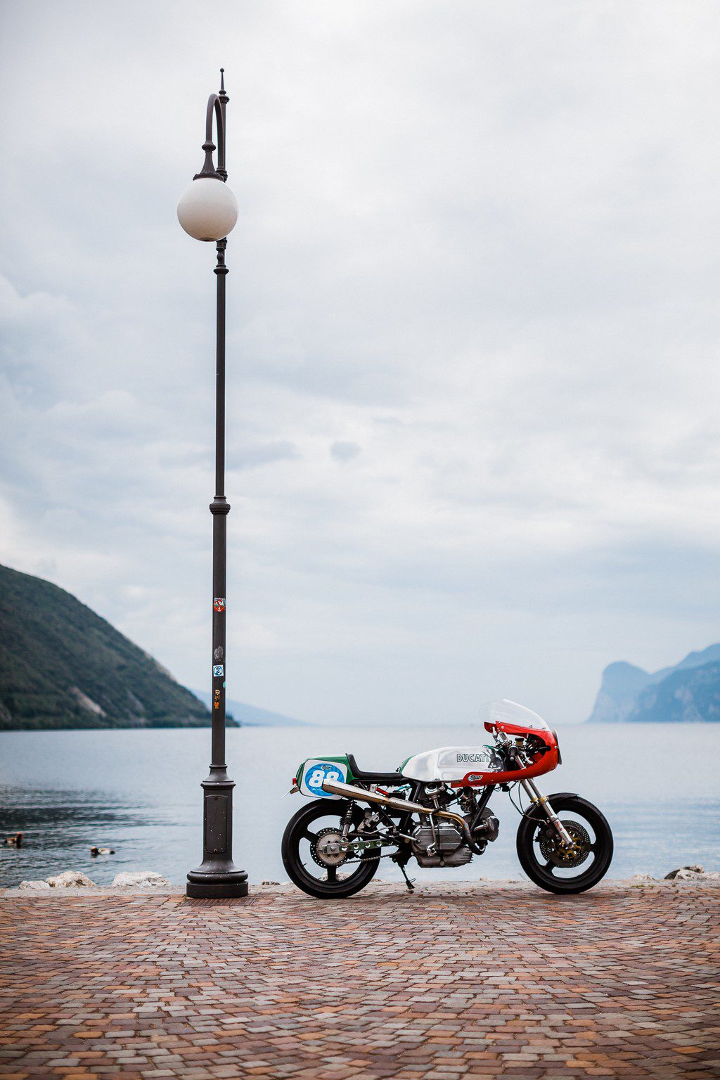  Ducati Road Racer motorcycle parked beside an Italian Lake