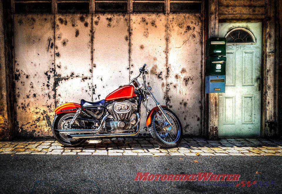 You don't need a motorcycle shipping guide to know you have to take good care of this baby Alt text: red motorcycle on the street in front of wall and door