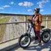 Female rider with ebike on bridge overlooking traffic