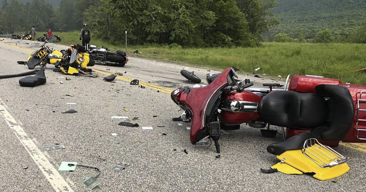 An image of two crashed motorcycles laying on tarmac, surrounded by debris.