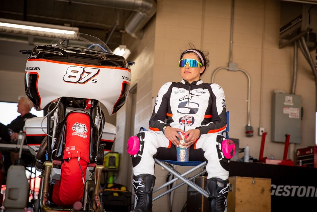 Patricia Fernandez sitting next to her Indian Racer Bagger at the Bagger Racing League