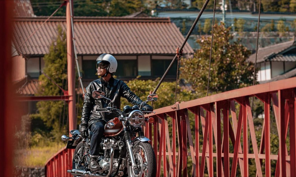 a rider enjoying the 2022 Kawasaki W800 on a red bridge