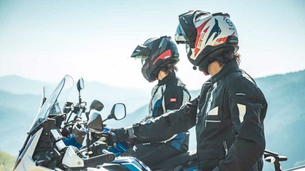 Two motorcyclists looking into the sunset. Media sourced from RideApart.