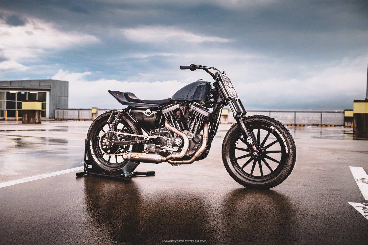 A Harley-Davidson flat tracker on an airport rooftop at dusk