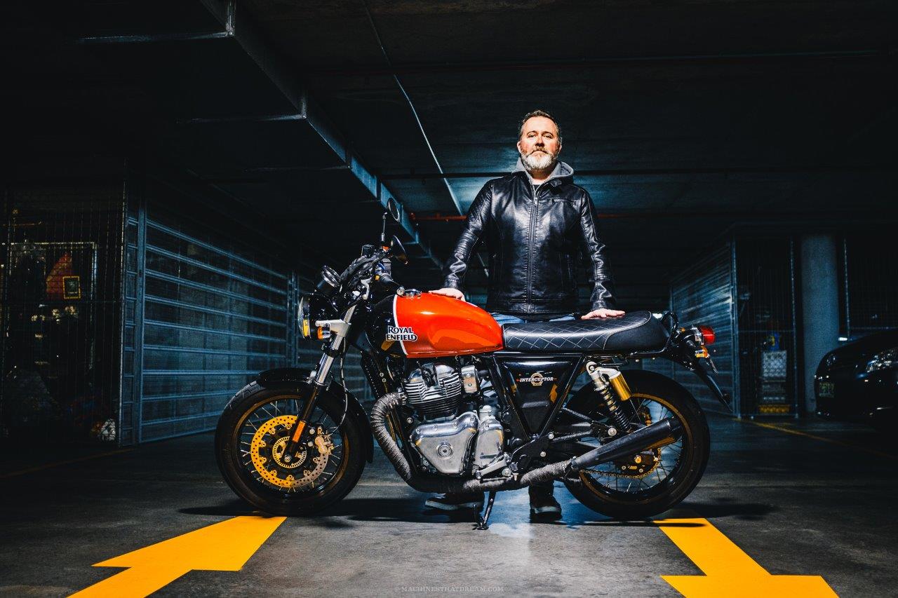 A Royal Enfield Interceptor in an underground carpark with owner