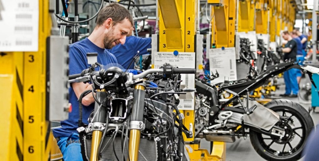 an employee working on a motorcycle on a factory floor