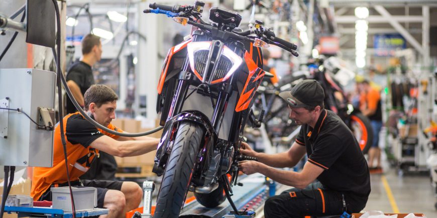 A worker putting the finishing touches on a KTM bike
