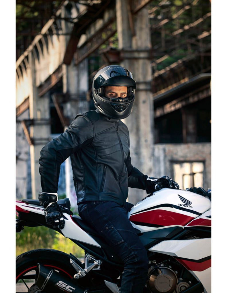 A view of a rider on a motorcycle wearing the new Neowise vegan leather motorcycle jacket from Andromeda Moto