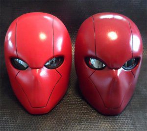 2 red hood helmets sitting side by side