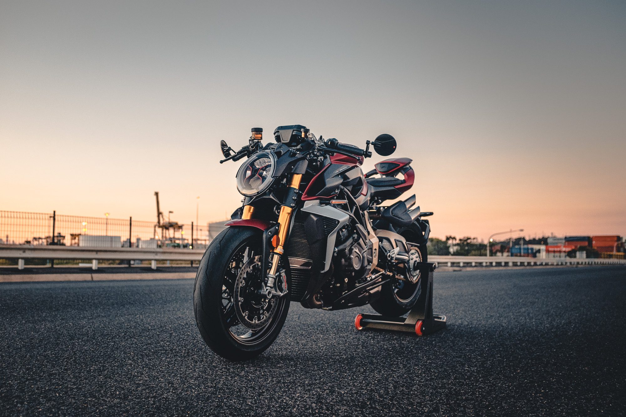 A MV Agusta Brutale motorcycle on an industrial road at sunset