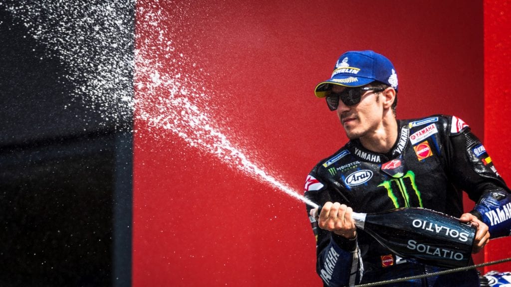 Maverick Vinales popping a bottle of champagne