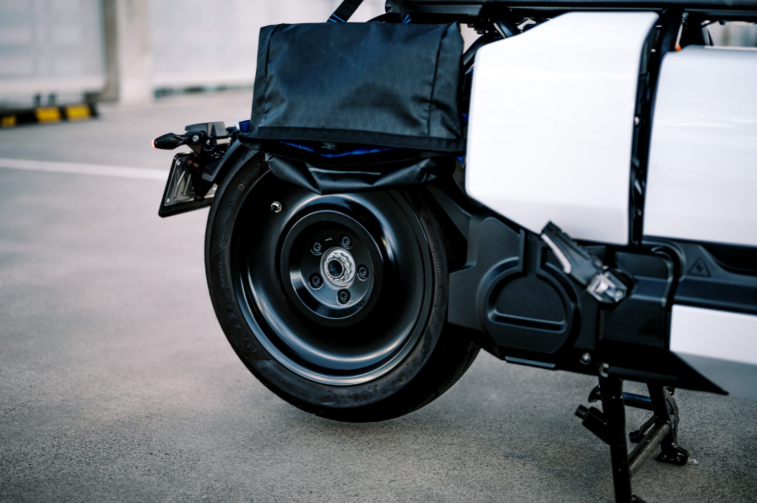 The rear wheel of BMW's CE-04 electric scooter on a carpark rooftop at sunset