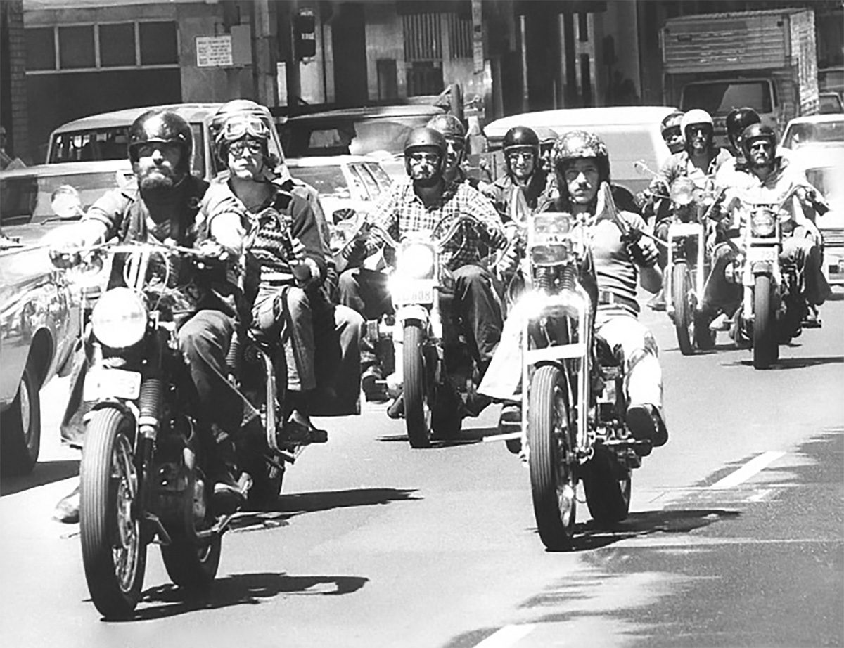 Australian motorcyclists ride through a city in the 1970s